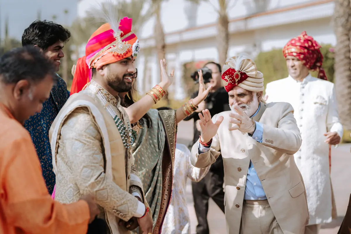 The baraat dances in with turbans and drums