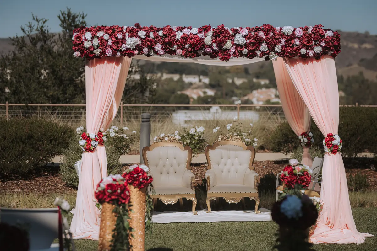 A flower-arched mandap in red and white