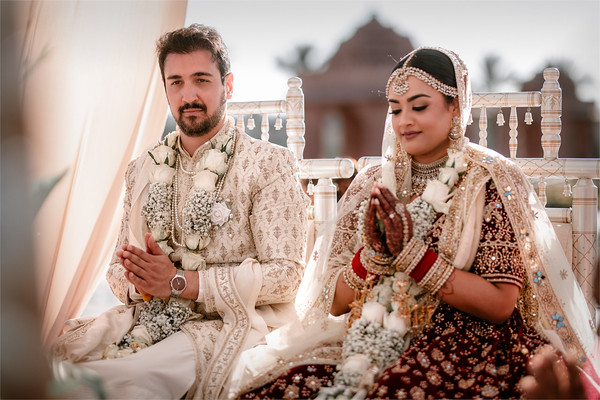 Seated, hands folded, mid-ceremony