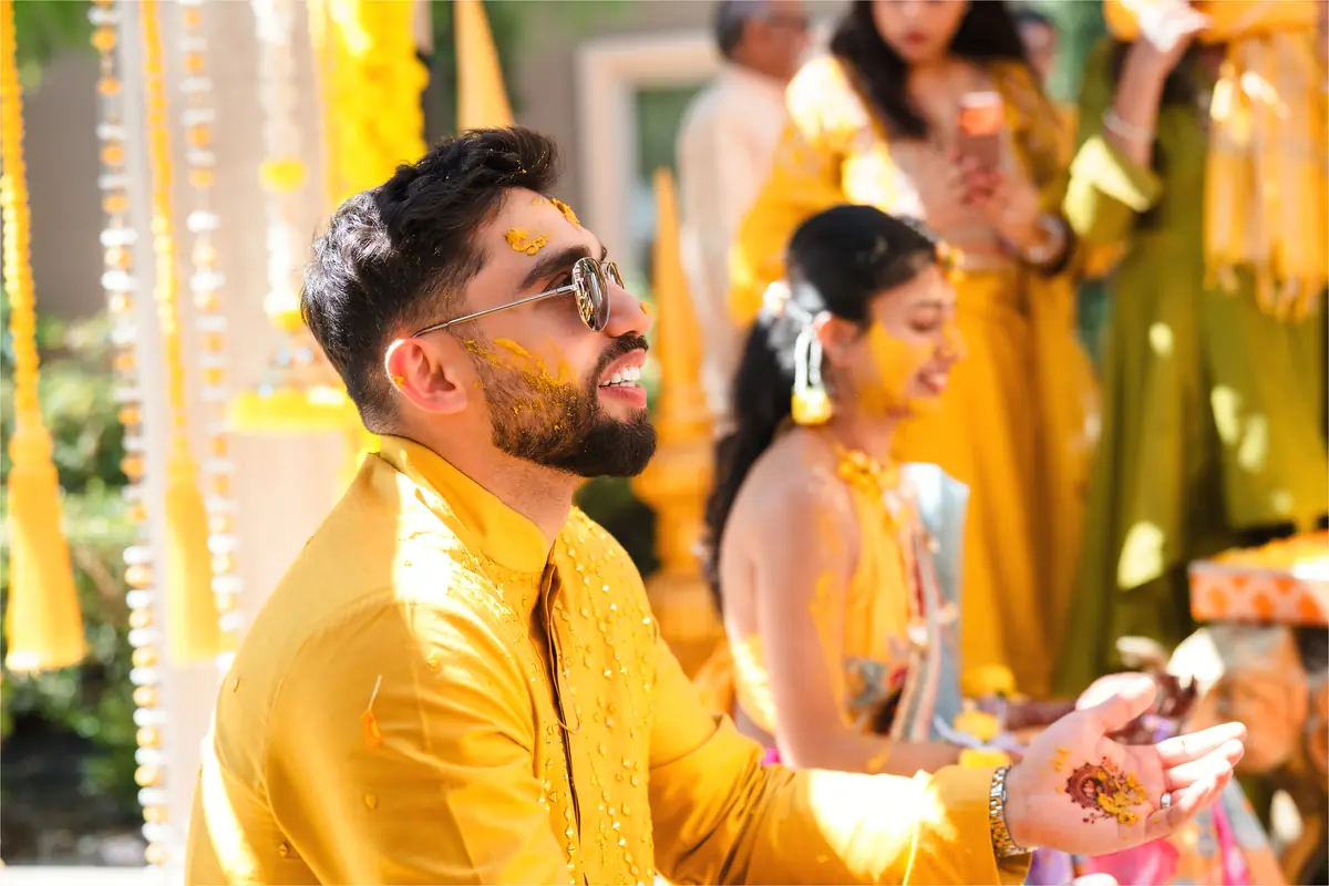 The groom mid-haldi, laughing