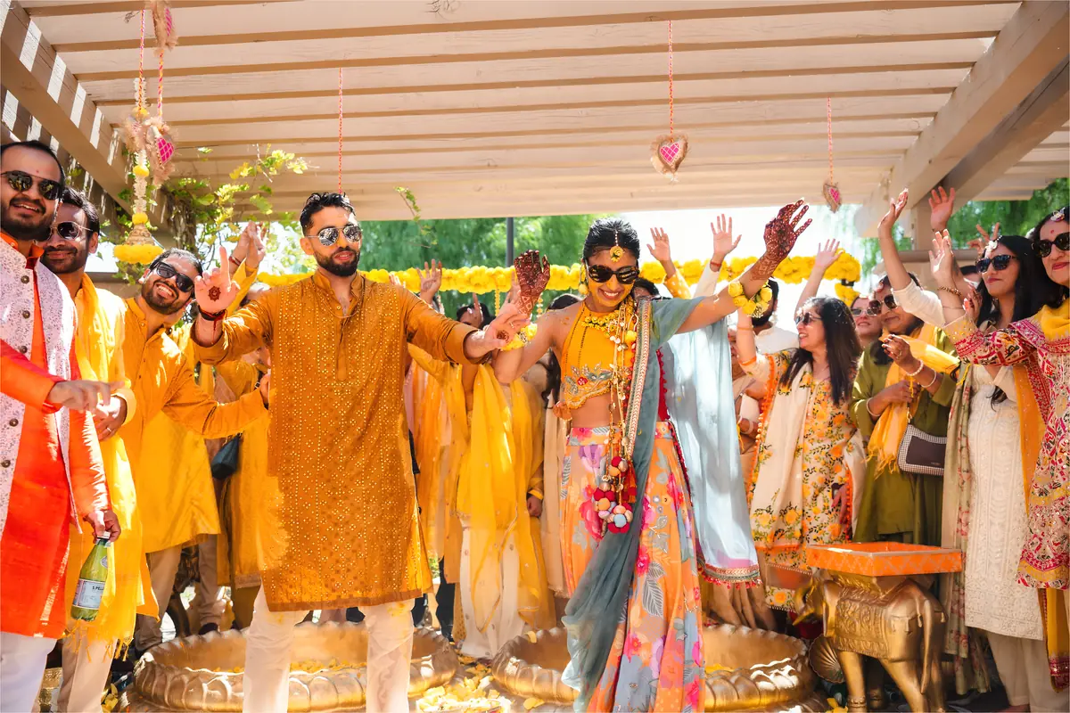 Hands raised under the haldi canopy