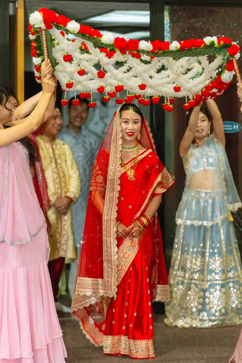 The bride enters under the flower canopy