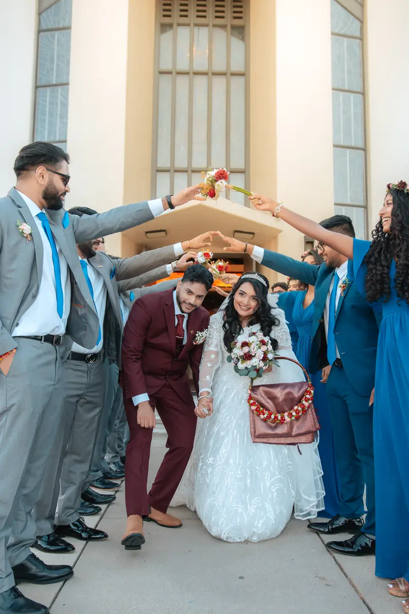 The wedding party under an arch of arms