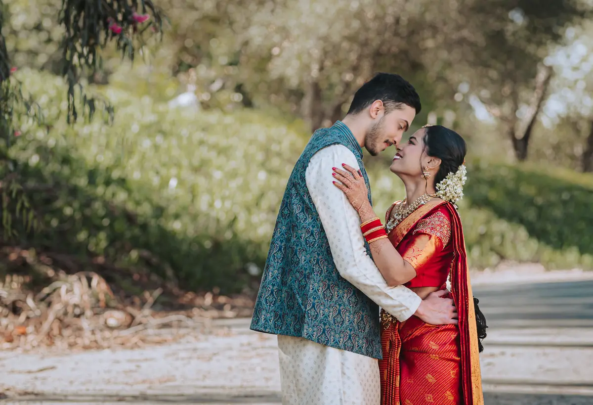 A couple in teal and crimson at golden hour