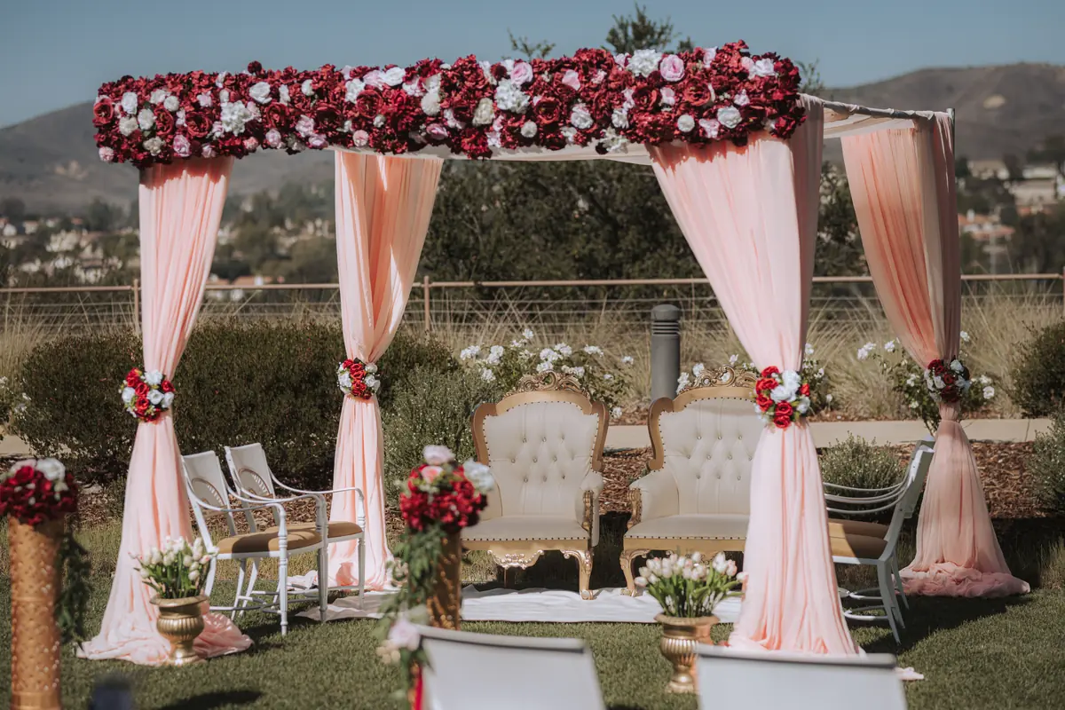 A rose-covered mandap and loveseat
